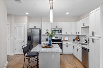 A kitchen with white cabinets and a marble countertop.at Century Grove Park, North Carolina, 27545